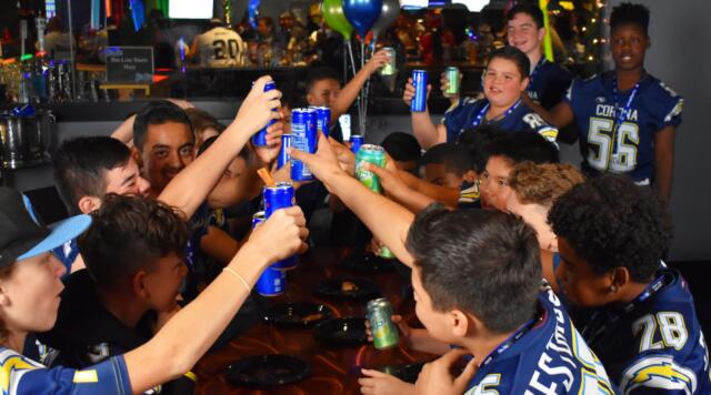 group of teens doing a cheers with their drinks.